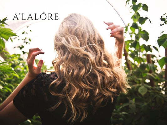 Doğal ortamda uzun dalgalı saçlara sahip kadının arka planda Alalore tuzsuz şampuan reklamı