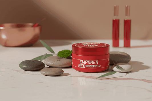 Alalore doğal parlak saç jeli kırmızı kapta beyaz mermer üzerinde taşlar ve yeşil yapraklarla